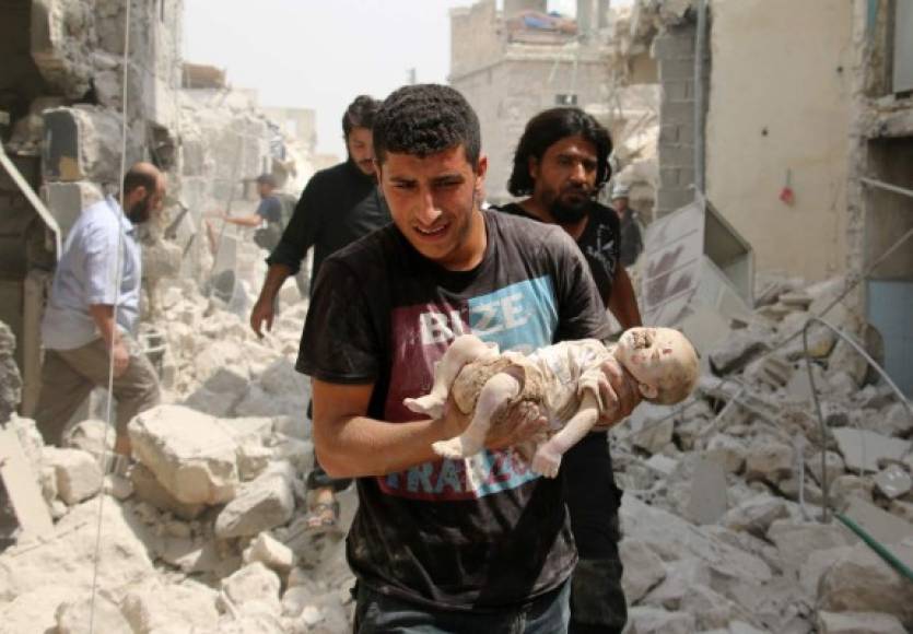 SIRIA. Los indefensos de la guerra. Un sirio carga a un bebé muerto durante un bombardeo del régimen en Bab al-Nairab, Alepo. Foto: AFP/Ameer Alhalbi