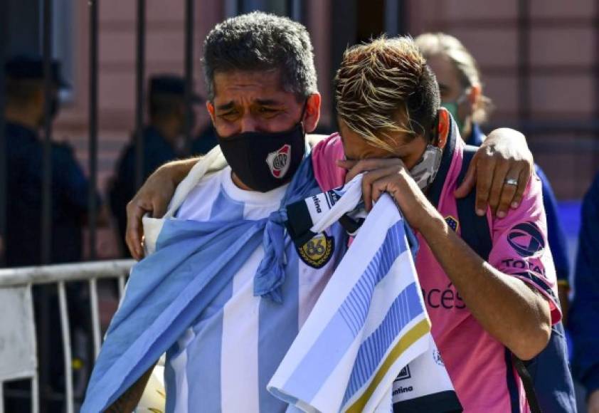 Abrazados y tristes por la muerte de Maradona.