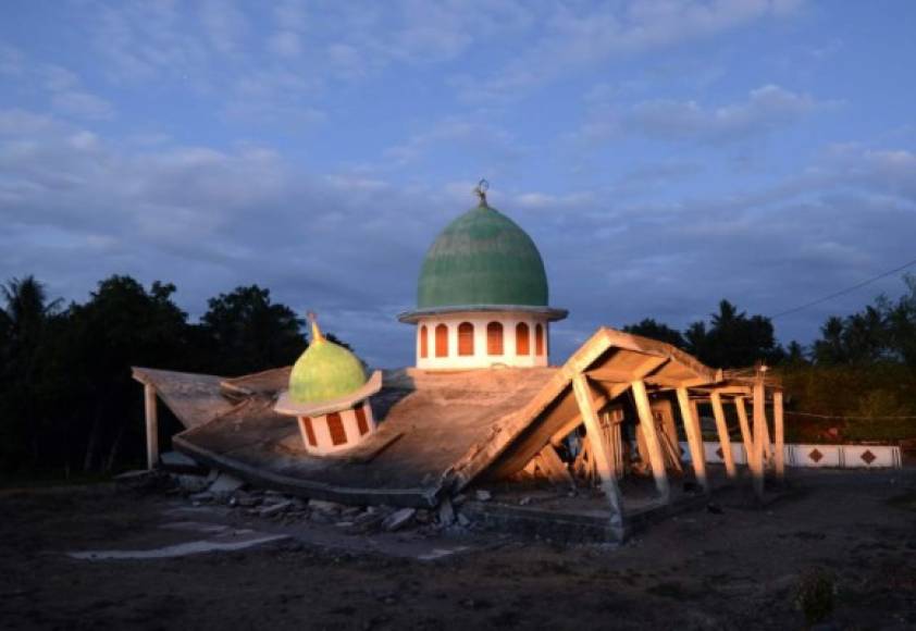 A collapsed mosque is seen as the sun set at Kayangan subdistrict in North Lombok on West Nusa Tenggara province on August 8, 2018, three days after an earthquake hit the area.<br/>More than 70,000 people left homeless by a deadly earthquake on the Indonesian island of Lombok are sleeping in makeshift shelters and lack food, medicine and clean water, officials said on August 8. / AFP PHOTO / SONNY TUMBELAKA
