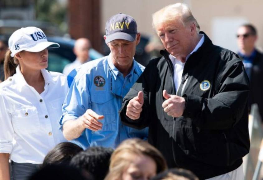 US President Donald Trump Florida Governor Rick Scott and First Lady Melania Trump hand out bottles of water as they tour damage from Hurricane Michael in Lynn Haven, Florida, October 15, 2018. - President Donald Trump visited Florida on Monday, nearly a week after Hurricane Michael slammed the southern US state, where thousands of people are struggling to survive without running water or electricity. Michael smashed into Florida's western coast on Wednesday as a powerful Category 4 storm, packing winds of 155 miles (250 kilometers) per hour as it began a northern march through several states on the United States' southeast coast, killing at least 17 people. (Photo by SAUL LOEB / AFP)