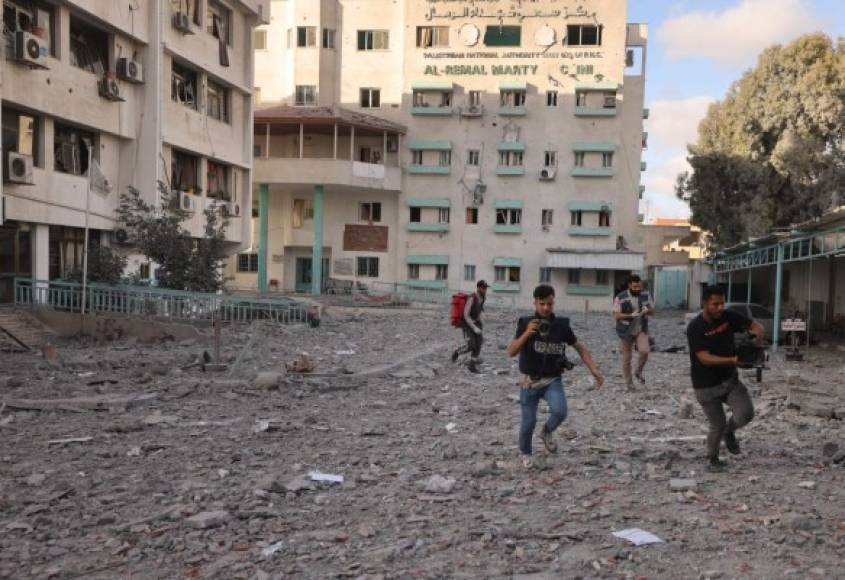 Los palestinos corren en medio de los ataques aéreos israelíes en la ciudad de Gaza el 17 de mayo de 2021. - Los aviones israelíes siguieron golpeando Gaza por la tarde, mientras los residentes del enclave palestino se encogían de miedo en el interior y la violencia que ha matado a más de 200 personas, la mayoría de ellos palestinos, entró en un segunda semana. (Foto de MOHAMMED ABED / AFP)