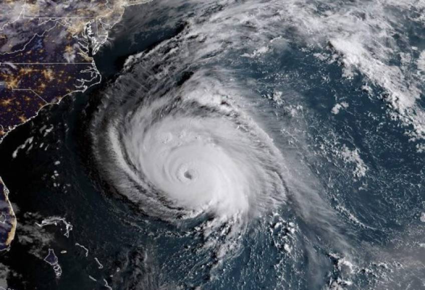 This NOAA/RAMMB satellite image taken at 10:00:30 UTC on September 12, 2018, shows Hurricane Florence off the US east coast in the Atantic Ocean.<br/><br/>Highways clogged with people fleeing North and South Carolina early Wednesday as monstrous Category 4 Hurricane Florence rumbled toward the eastern US as the biggest storm there in decades. While many coastal residents heeded mandatory evacuation orders, others boarded up homes and businesses and chose to brave the storm, which is forecast to trigger severe flash flooding as it dumps as many as three feet (almost a meter) of rain in some areas. Life-threatening storm surges of up to a staggering 13 feet in some places were also forecast.<br/><br/> / AFP PHOTO / NOAA/RAMMB / HO / RESTRICTED TO EDITORIAL USE - MANDATORY CREDIT 'AFP PHOTO / NOAA/RAMMB' - NO MARKETING NO ADVERTISING CAMPAIGNS - DISTRIBUTED AS A SERVICE TO CLIENTS<br/><br/>