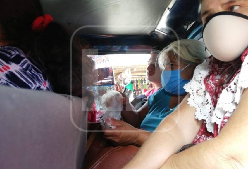 Un bus de la ruta Chamelecón-Centro, madre e hijo viajan con la mascarilla en la barbilla y comparten un jugo, mientras que el ciudadano de atrás consume una bebida.