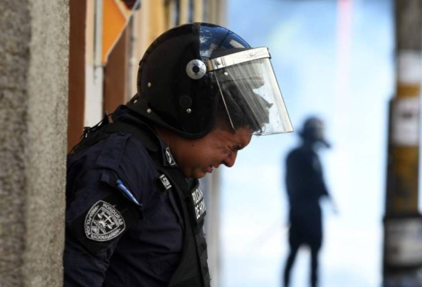 Este agente policial resiente el olor de los gases mientras combatían a los protestantes. En pleno centro también se quemaron llantas.