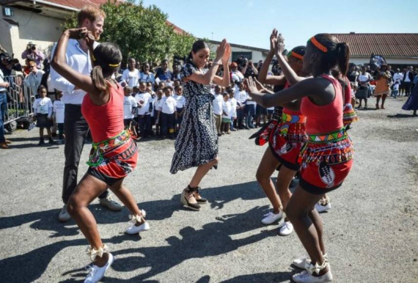 El primer día de su gira de 10 días por varios países del continente comenzó en Ciudad del Cabo.<br/><br/>Harry y Meghan bailaron un poco con un grupo de bailarinas que les dieron una bienvenida musical en el municipio de Nyanga.