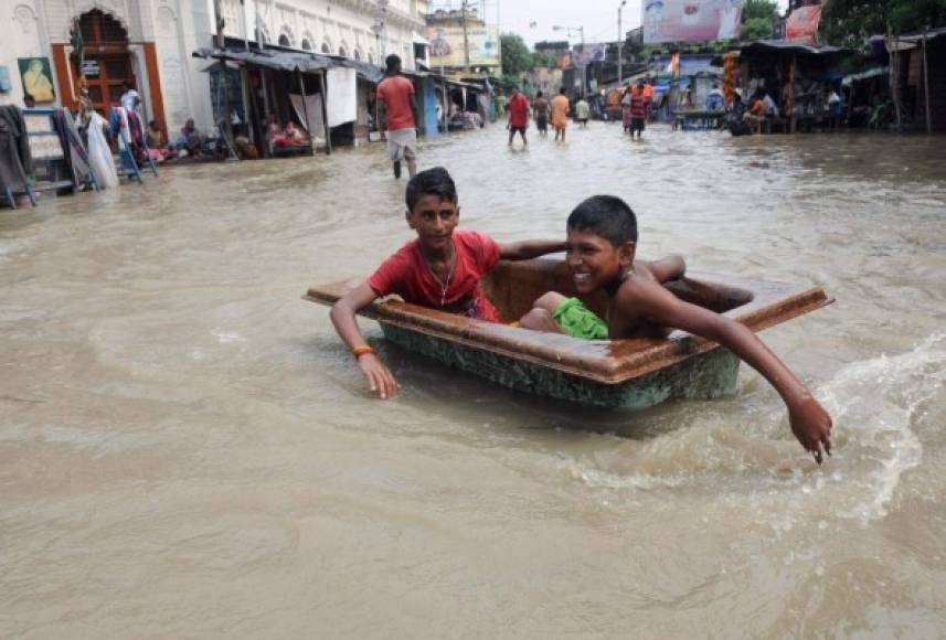 India. Las inundaciones han provocado varios muertos en los últimos días pero estos niños lo pasan en grande.