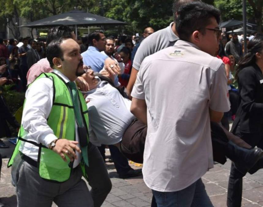 A woman is assisted after a quake rattled Mexico City on September 19, 2017.<br/>A powerful earthquake shook Mexico City on Tuesday, causing panic among the megalopolis' 20 million inhabitants on the 32nd anniversary of a devastating 1985 quake. The US Geological Survey put the quake's magnitude at 7.1 while Mexico's Seismological Institute said it measured 6.8 on its scale. The institute said the quake's epicenter was seven kilometers west of Chiautla de Tapia, in the neighboring state of Puebla.<br/> / AFP PHOTO / Yuri CORTEZ