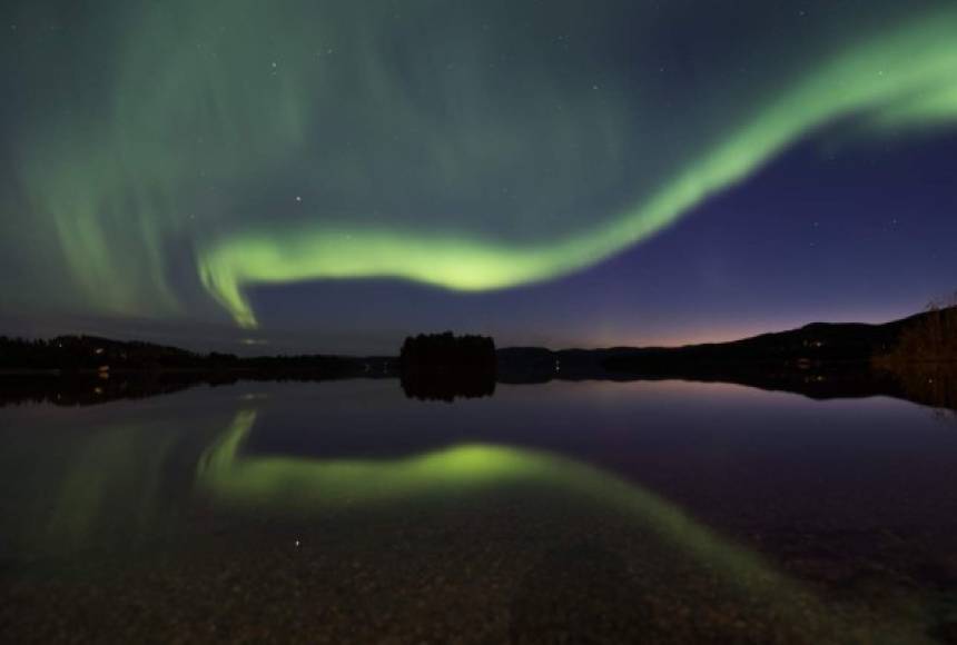 Las luces del norte de la aurora boreal iluminan el cielo en la villa de Erikslund en Suecia.
