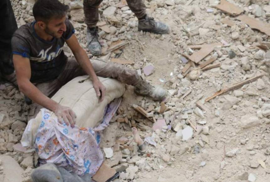 Los bombardeos han destruido infraestructuras esenciales, como centros sanitarios, y de suministro eléctrico y de agua. En la imagen un hombre observa el pie de un niño sepultado en los escombros tras un bombardeo.