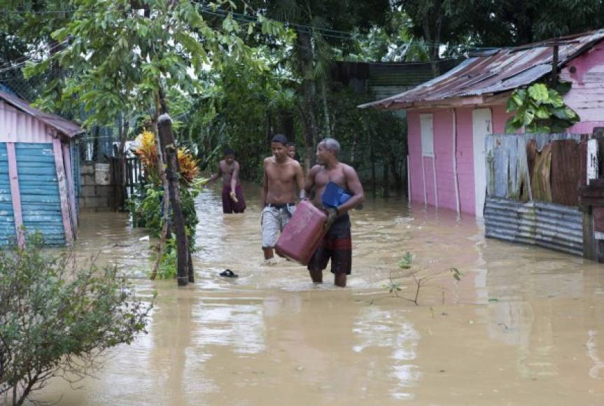 Residentes del barrio La Florida caminan por una calle inundada, tras el paso del huracán María en Higüey (República Dominicana).