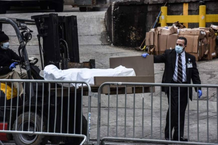 Los empleados se ayudan de pequeños vehículos montacarga para colocar los cuerpos en los furgones, estacionados en las afueras de cada hospital de Nueva York.