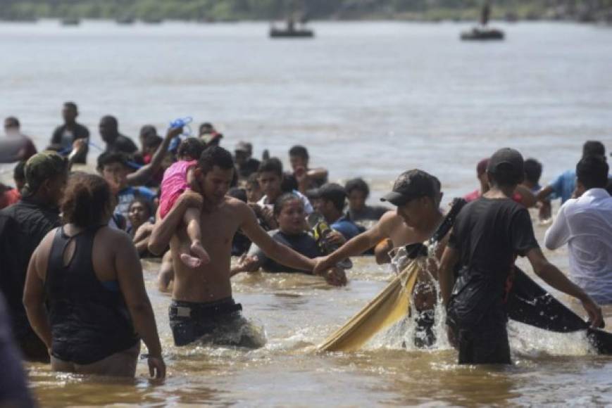 La marea humana, formada por centenares de mujeres, hombres y niños, intenta atravesar caminando este caudal que a muchos el agua les llega al pecho, mientras la policía mexicana espera de pie en la orilla.