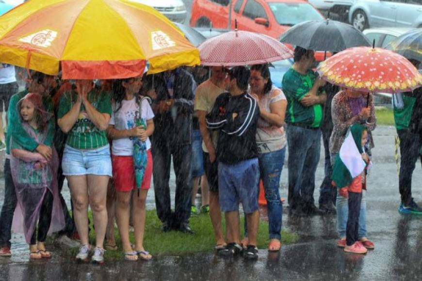 La gente esperó en la calles bajo la lluvia la llegada de su equipo.