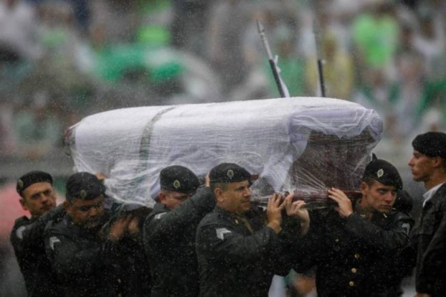 Una guardia militar de honor carga con los ataúdes de los jugadores para la ceremonia conmemorativa.