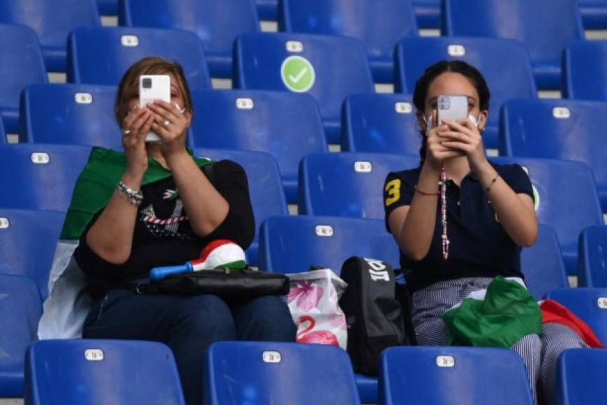 Acompañas de la bandera italiana, aficionadas registran con sus teléfonos los momentos en Roma, previo al duelo inaugural de la Euro. Italia es una de las candidatas, aunque no por delante de la campeona del mundo Francia o Portugal, que defiende el cetro europeo.