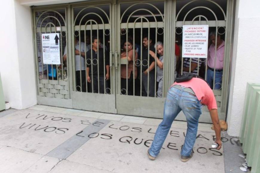 Un estudiante pinta un graffiti en la entrada del Congreso de Guerrero.