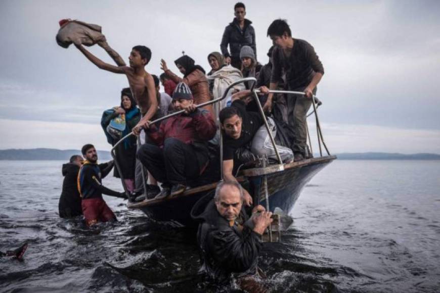 El primer lugar en la categoría de Noticias Generales fue para esta imagen que muestra a un grupo de refugiados llegar en bote a las costas de Lesbos, en Grecia.