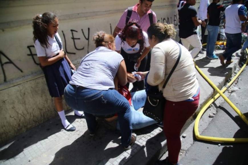 Esta mujer se desmayó producto de los gases lacrimónegos, pero otros protestantes la auxiliaron.