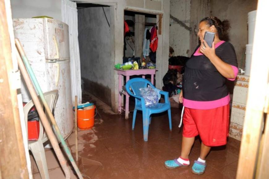 Una mujer observa su vivienda que ha sido afectada por las lluvias.