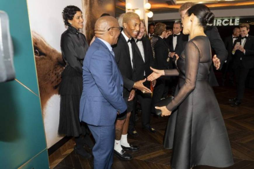 Britain's Prince Harry, Duke of Sussex and Britain's Meghan, Duchess of Sussex (R) greet US singer Pharrell Williams (C) as they arrive to attend the European premiere of the film The Lion King in London on July 14, 2019. (Photo by Niklas HALLE'N / POOL / AFP)