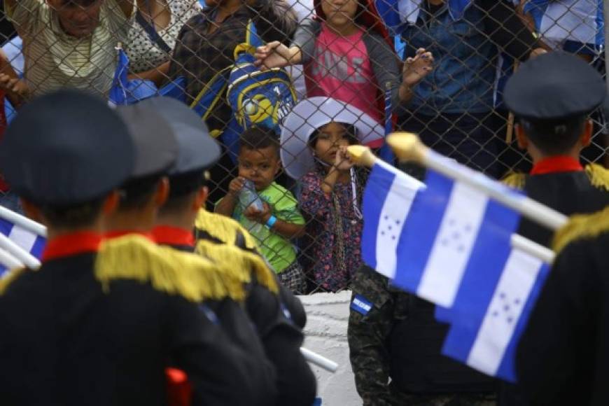 Dos niños observan desde las graderías a los cadetes de la Policía Nacional.