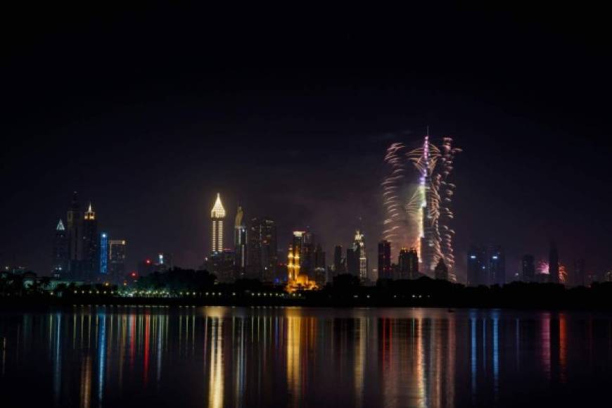 Los fuegos artificiales iluminan el paisaje de Dubai, en los Emiratos Árabes Unidos.