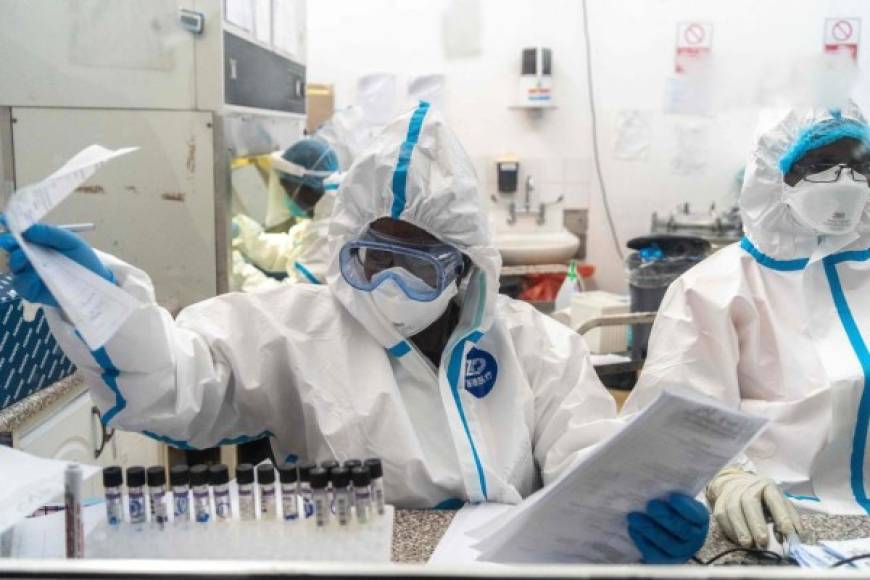 Members of National University of Science and Technology (NUST) work on specimens in a COVID-19 laboratory testing centre on April 25, 2020, at Mpilo Hospital in Bulawayo, Zimbabwe. - The number of cases of coronavirus in Africa is currently low compared to the rest of the planet: nearly 28,000 on the continent against more than 2.7 million worldwide, according to an AFP count. (Photo by ZINYANGE AUNTONY / AFP)