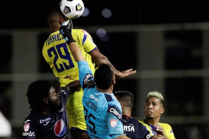 Román Torres de Universitario le gana la pelota en el aire al arquero Marlon Licona.