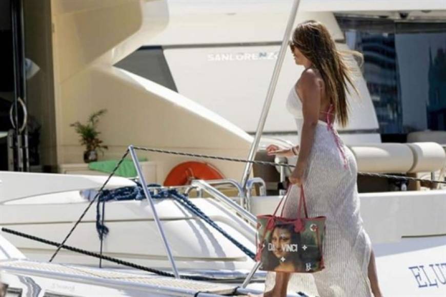 Antonela Roccuzzo, mujer de Lionel Messi, en el momento que se sube al yate con su bolso artístico Da Vinci. FOTO LECTURAS.COM.