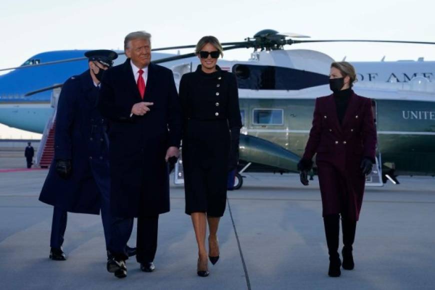 Outgoing US President Donald Trump and First Lady Melania Trump(C) walk from Marine One at Joint Base Andrews in Maryland on January 20, 2021. - President Trump travels his Mar-a-Lago golf club residence in Palm Beach, Florida, and will not attend the inauguration for President-elect Joe Biden. (Photo by ALEX EDELMAN / AFP)