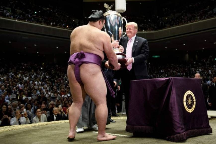 El ganador, conocido por su nombre deportivo de Asanoyama, recibió el trofeo de parte de Trump, quien tuvo que ser ayudado por el peso de la copa, de unos 30 kilos, que fue entregada en el círculo de arena conocido como 'dohyu'.