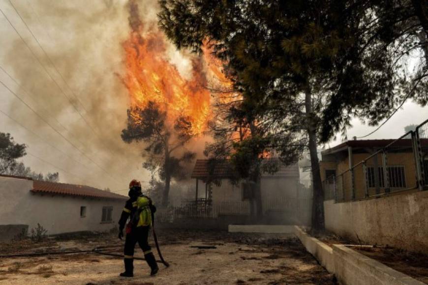 TOPSHOT - A firefighter tries to extinguish hotspots during a wildfire in Kineta, near Athens, on July 23, 2018. <br/>More than 300 firefighters, five aircraft and two helicopters have been mobilised to tackle the 'extremely difficult' situation due to strong gusts of wind, Athens fire chief Achille Tzouvaras said. / AFP PHOTO / VALERIE GACHE