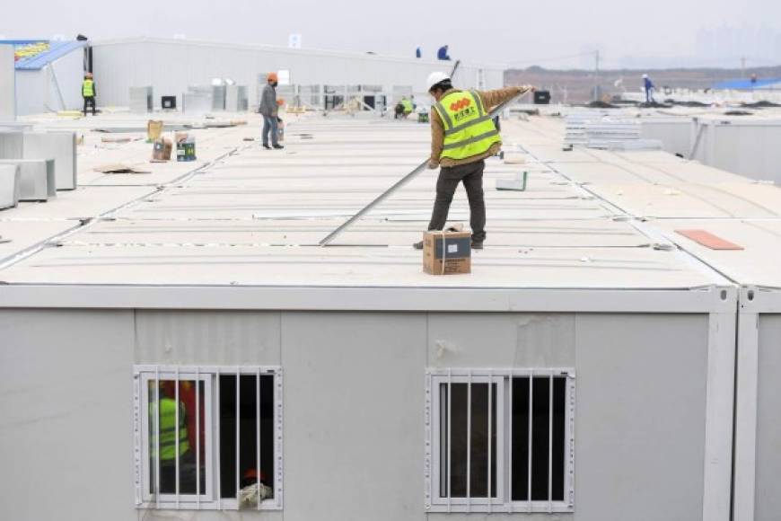 Obreros chinos realizan los últimos retoques antes de que el nuevo hospital abra sus puertas este lunes.