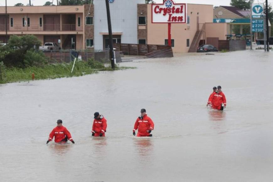 Miembros de la Guardia Costera continúan trabajando para rescatar a las personas atrapadas por las inundaciones.