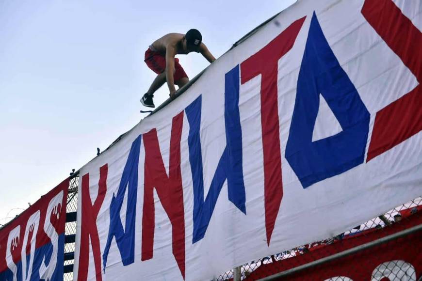 Este aficionado del Olimpia se ariesgó al subirse al alambrado del estadio Morazán para colocar una manta.