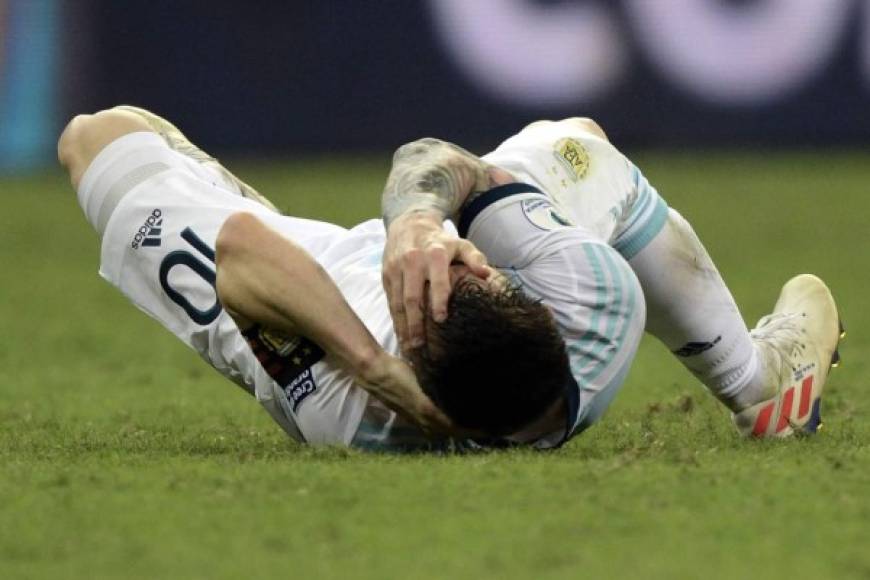 Messi, tendido en el suelo, se lleva las manos a la cara tras el golpe que se llevó.