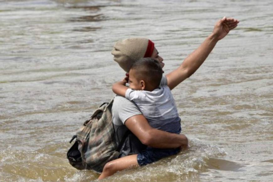 Los niños se aferraban a sus padres mientras cruzaban las turbulentas aguas del río Suchiate.