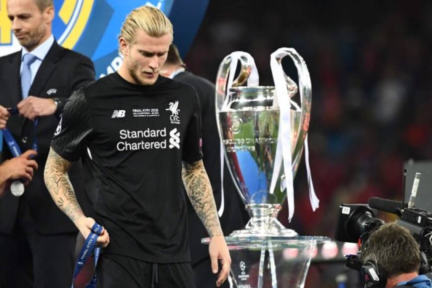 Liverpool's German goalkeeper Loris Karius walks past the trophy after losing the UEFA Champions League final football match between Liverpool and Real Madrid at the Olympic Stadium in Kiev, Ukraine, on May 26, 2018. / AFP PHOTO / FRANCK FIFE