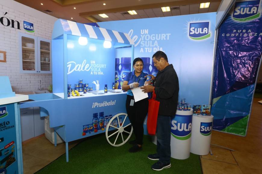 Una joven da una degustación de yogur de la marca Sula a unos de los asistentes de la Expo Buen Provecho.