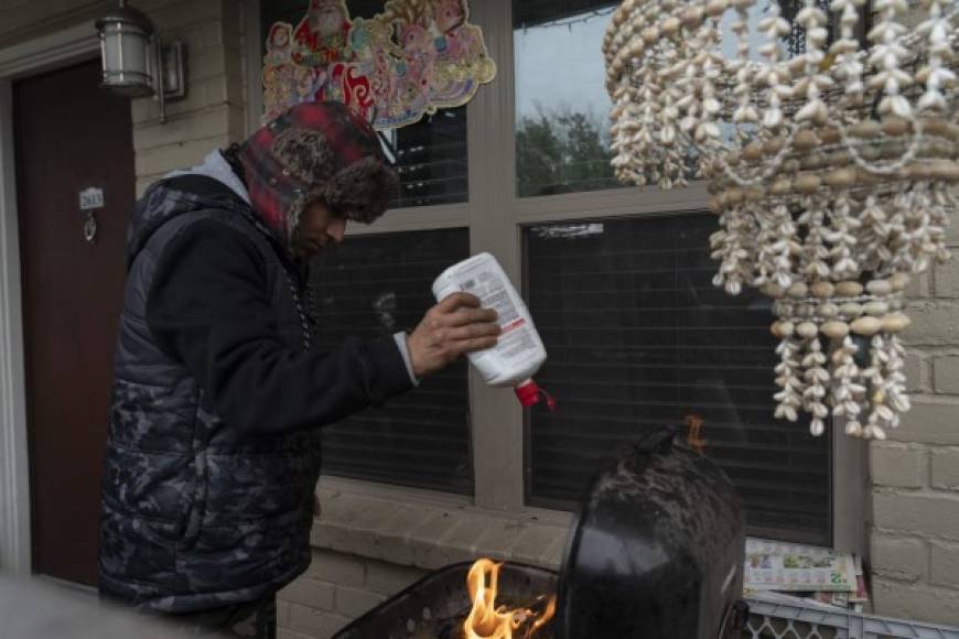 Ante la falta de energía para encender los calentadores, los residentes de Texas han improvisado medidas para huir al frío, como Víctor Zelaya, que encendió una parrilla para recibir un poco de calor.