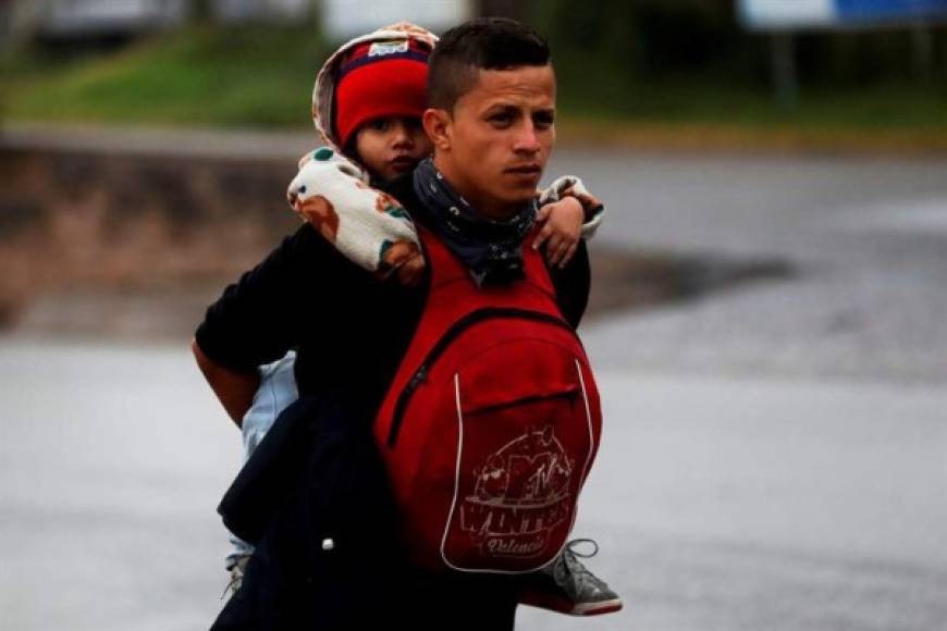 Los migrantes, muchos de ellos con niños en sus espaldas, iniciaron la caminata bajo una fuerte lluvia derivada de un frente frío que azota a Guatemala.