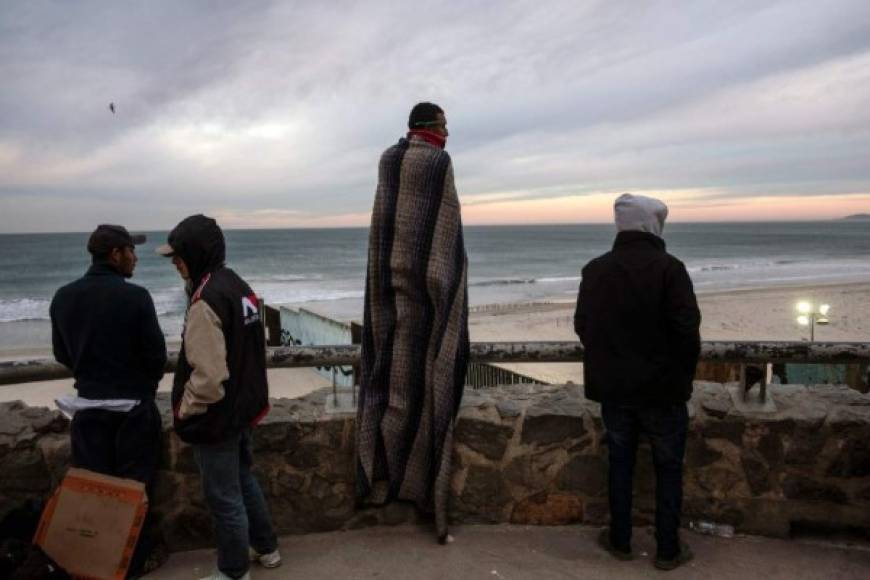 Central American migrants -mostly Hondurans- moving towards the United States in hopes of a better life, are seen near the US-Mexico border fence in Playas de Tijuana, Mexico, on November 14, 2018. - US Defense Secretary Jim Mattis said Tuesday he will visit the US-Mexico border, where thousands of active-duty soldiers have been deployed to help border police prepare for the arrival of a 'caravan' of migrants. (Photo by Guillermo Arias / AFP)