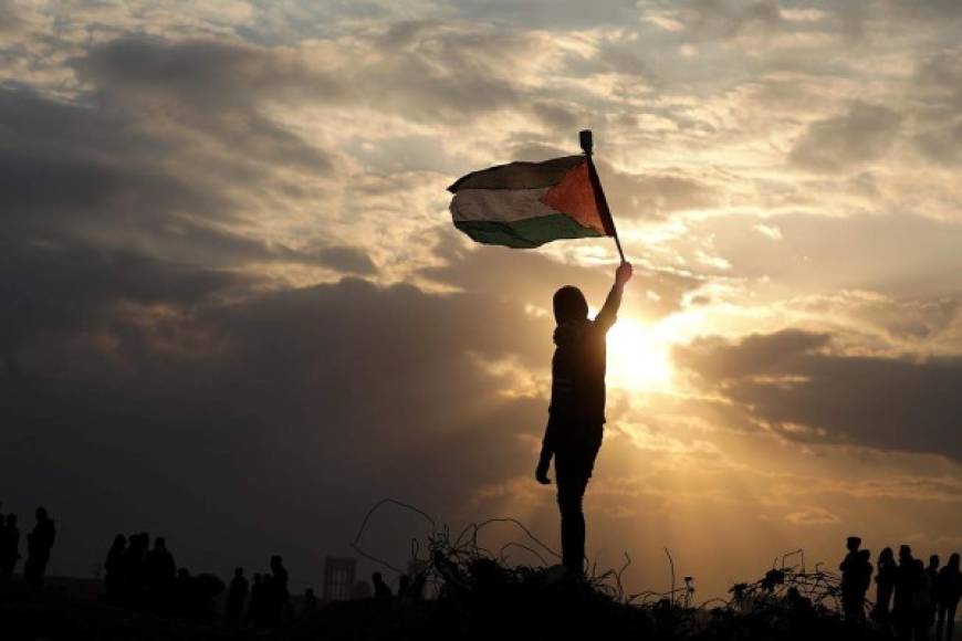Gaza. <br/>Iza la bandera palestina al ocaso. Un joven con la bandera palestina, cerca de la frontera de Gaza con Israel. Sigue disputa porque EUA reconoció a Jerusalén como capital de Israel.