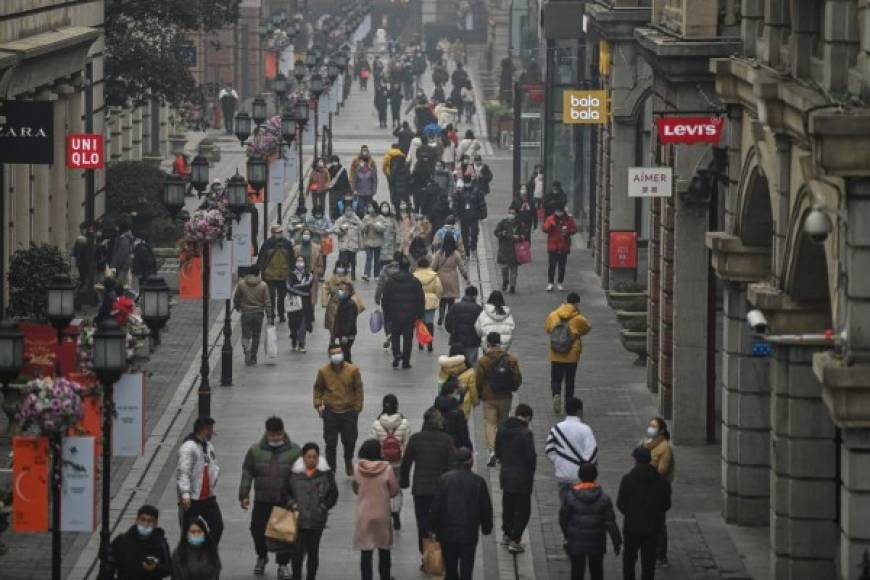 TOPSHOT - People walk along a pedestrian street in Wuhan, China's central Hubei province on January 23, 2021, one year after the city went into lockdown to curb the spread of the Covid-19 coronavirus. (Photo by Hector RETAMAL / AFP)