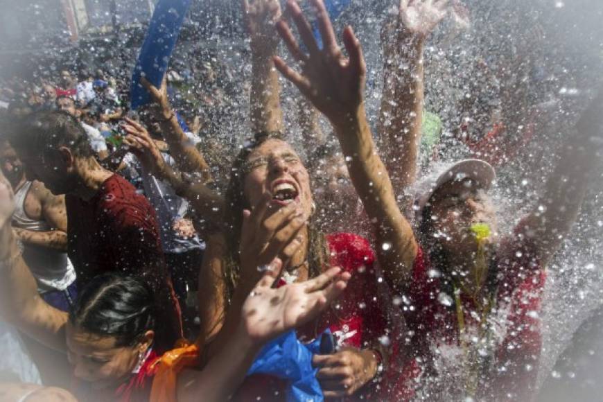 ESPAÑA. La fiesta del agua. Personas reciben agua en la procesión de San Roque en la Plaza de Galicia de Vilagarcía de Arousa.