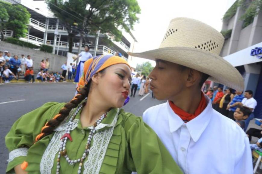 Dos jóvenes simulan darse un beso durante un acto cívico en San Pedro Sula, zona norte de Honduras.