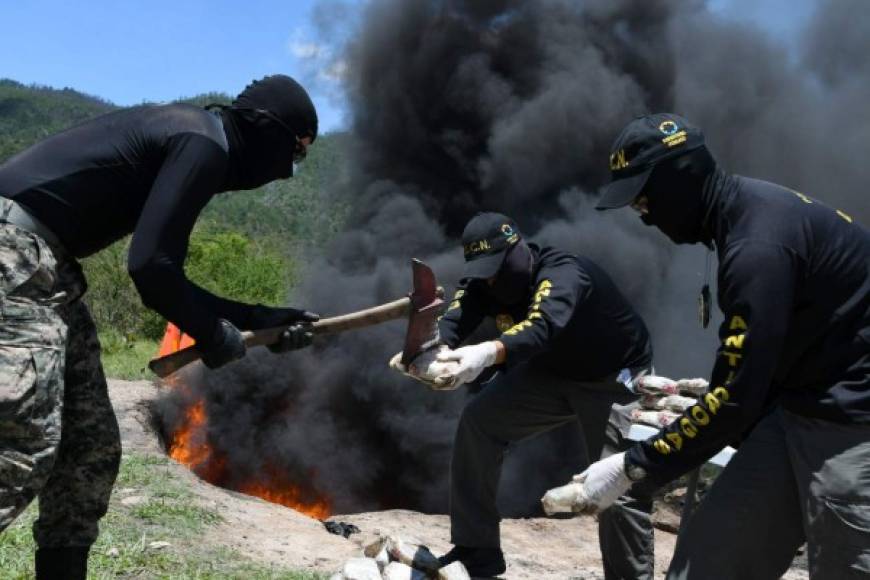 Miembros de la Oficina Antinarcóticos queman 200 kilos de cocaína incautados en abril en un avión que se estrelló en la remota provincia de Gracias a Dios. AFP