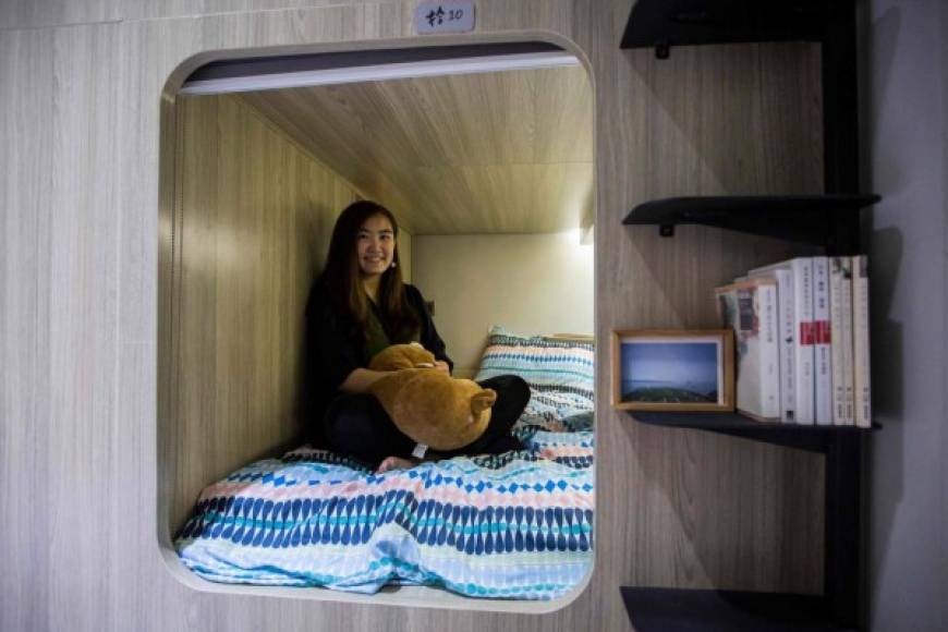 Michelle Chau posa en la cama que renta en un pequeño espacio de un apartamento co compartido con otras siete personas en Hong Kong.
