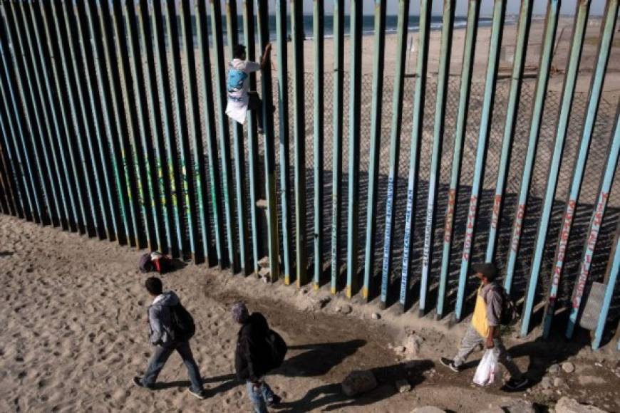 Al menos 300 migrantes llegaron a pie hasta la zona de Playas de Tijuana donde el cerco fronterizo se interna en las aguas del Pacífico, y varios de ellos escalaron la valla que divide a San Diego de Tijuana.