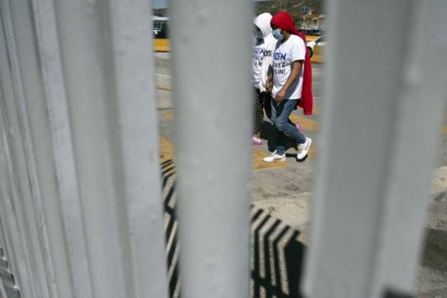 Migrantes caminan después de una manifestación exigiendo políticas migratorias más claras de Estados Unidos en el puerto de cruce de San Ysidro en Tijuana, estado de Baja California, México. AFP